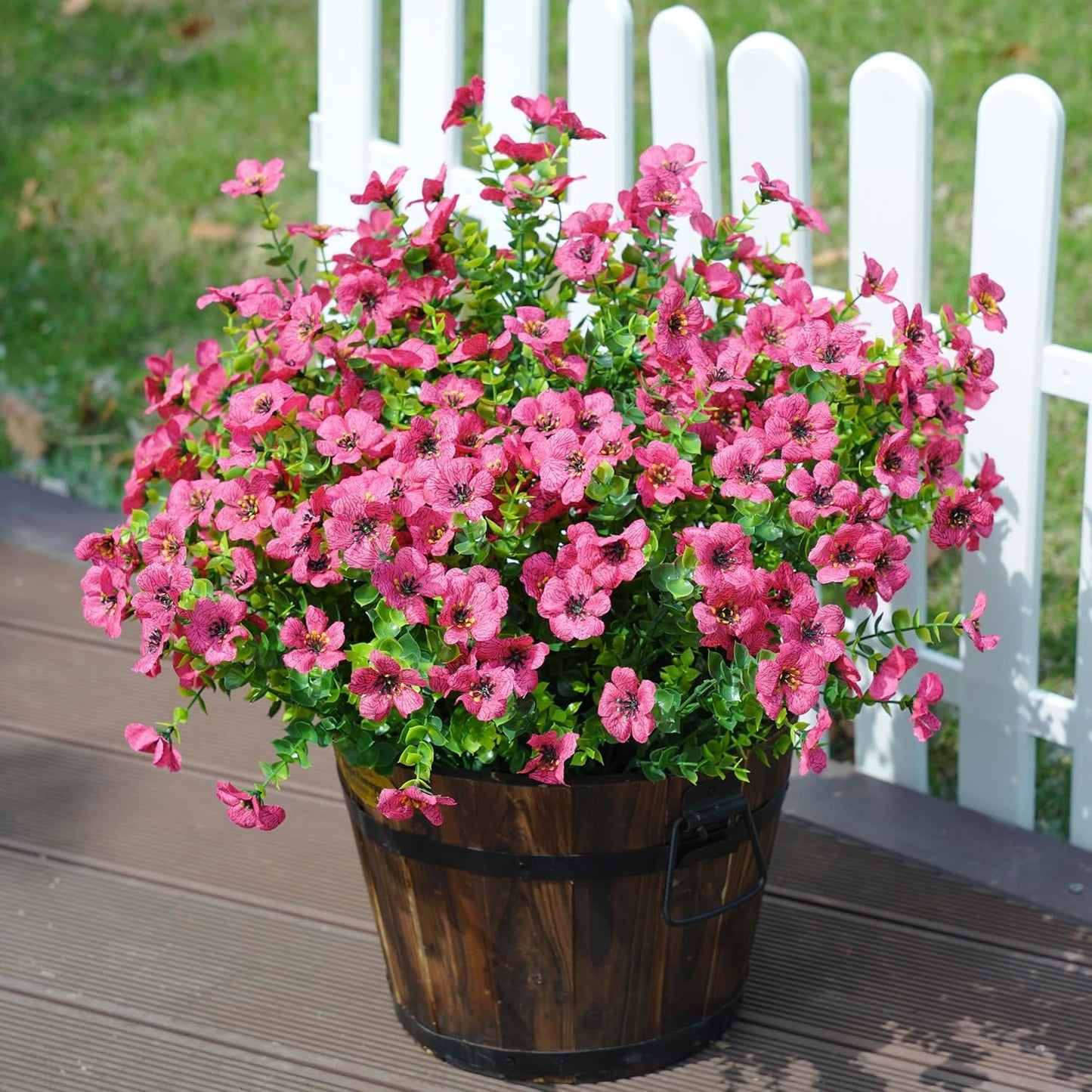 Potted plant with pink flowers on a wooden deck