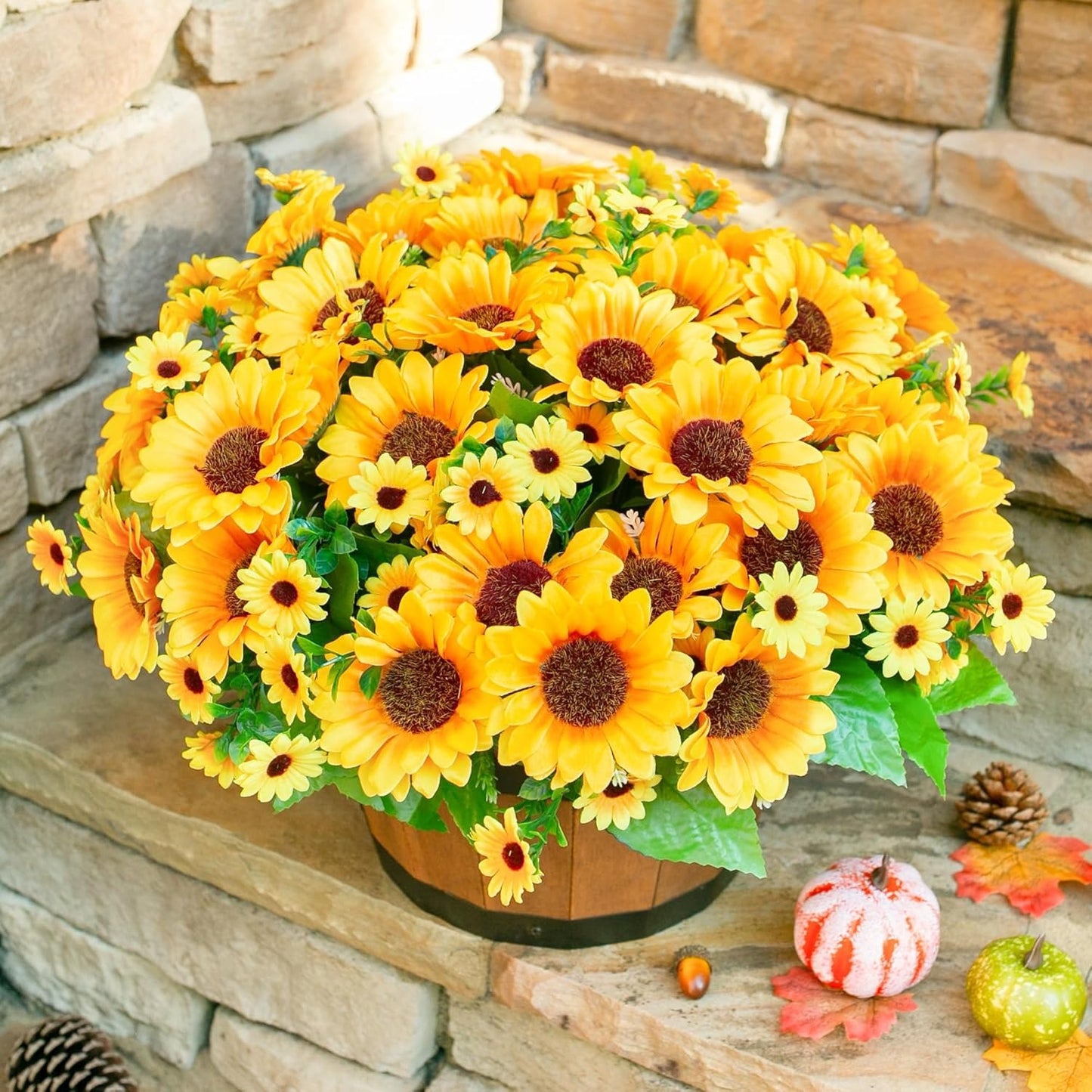 Bouquet of yellow sunflowers in a wooden basket against a stone wall background