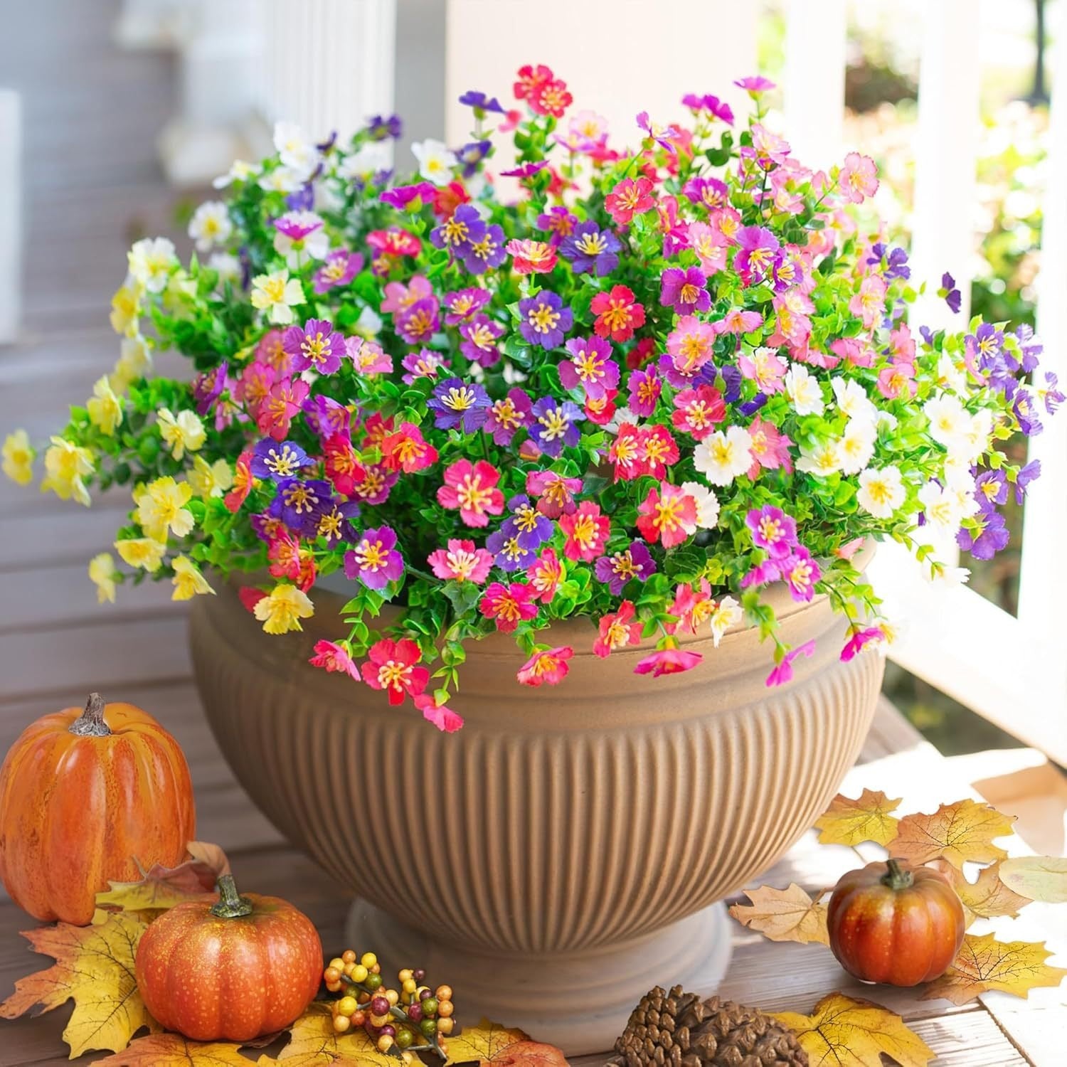 Colorful potted plant with pumpkins and autumn leaves on a table