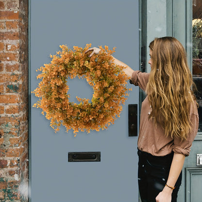 Woman placing a wreath on a blue door next to a brick wall