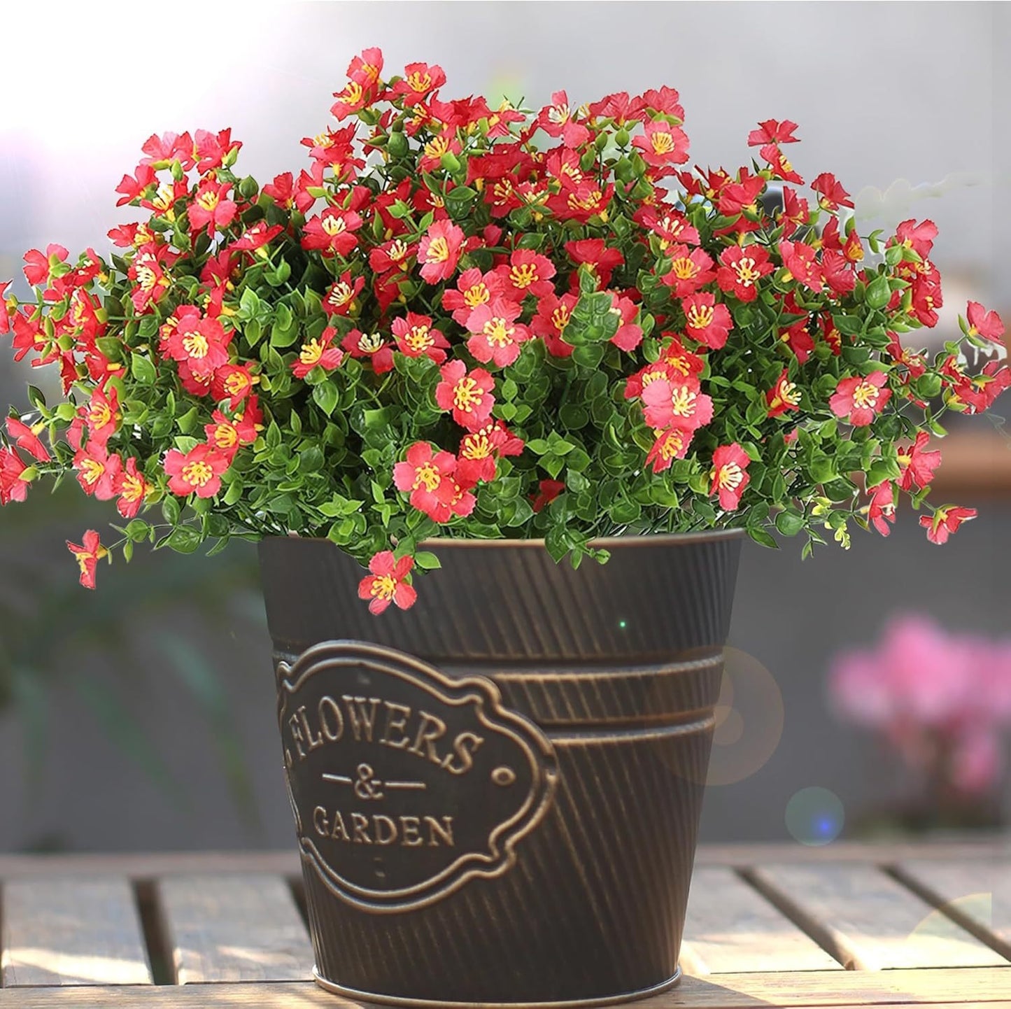 Potted plant with red flowers in a decorative pot on a wooden surface